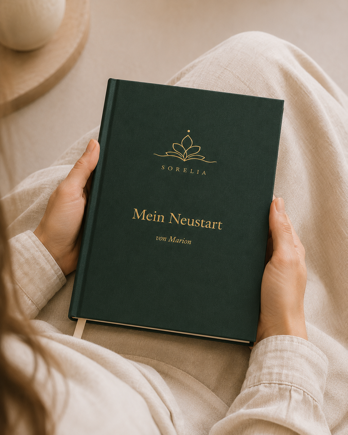 Ein grünes Sorelia-Buch mit Goldprägung in zwei Händen